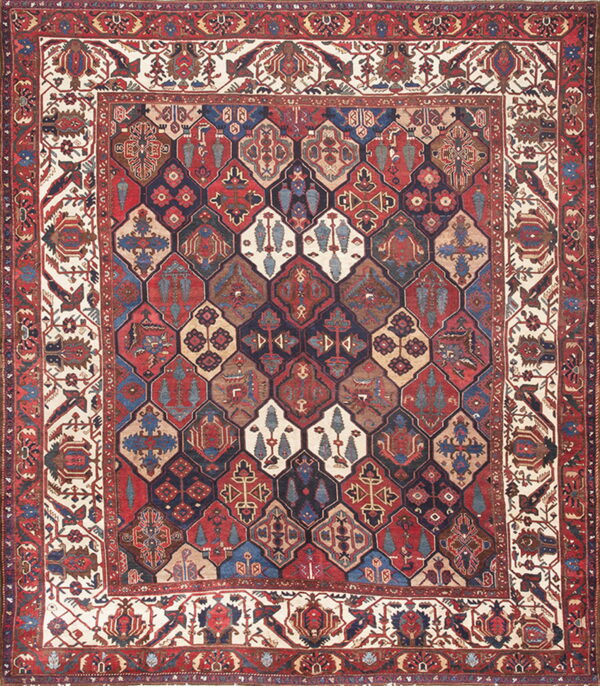 Rich red and blue rug featuring a field of complex interlocking geometric medallions and wide patterned borders.