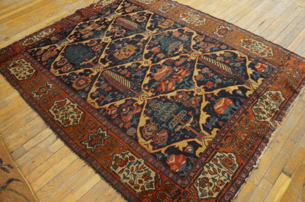 Low-pile rug with a navy, rust, and gold geometric lattice pattern on light plank flooring.