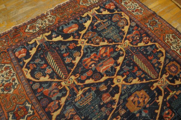 Detailed view of a low-pile rug with navy, rust, gold, and teal traditional geometric patterns on wood flooring.