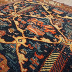 Intricate low pile rug featuring navy, rust, and gold geometric patterns partially covering light plank flooring.