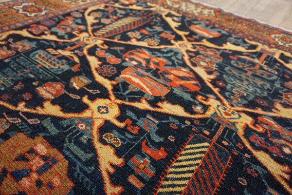 Intricate low pile rug featuring navy, rust, and gold geometric patterns partially covering light plank flooring.