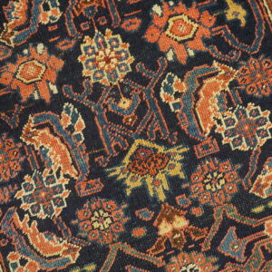 Short-pile rug detail showing rust, indigo, and ivory geometric floral designs.