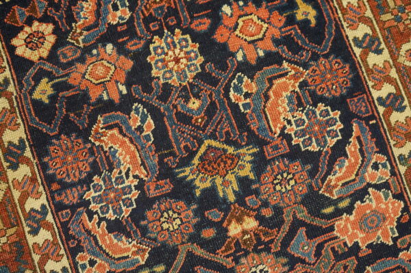 Short-pile rug detail showing rust, indigo, and ivory geometric floral designs.