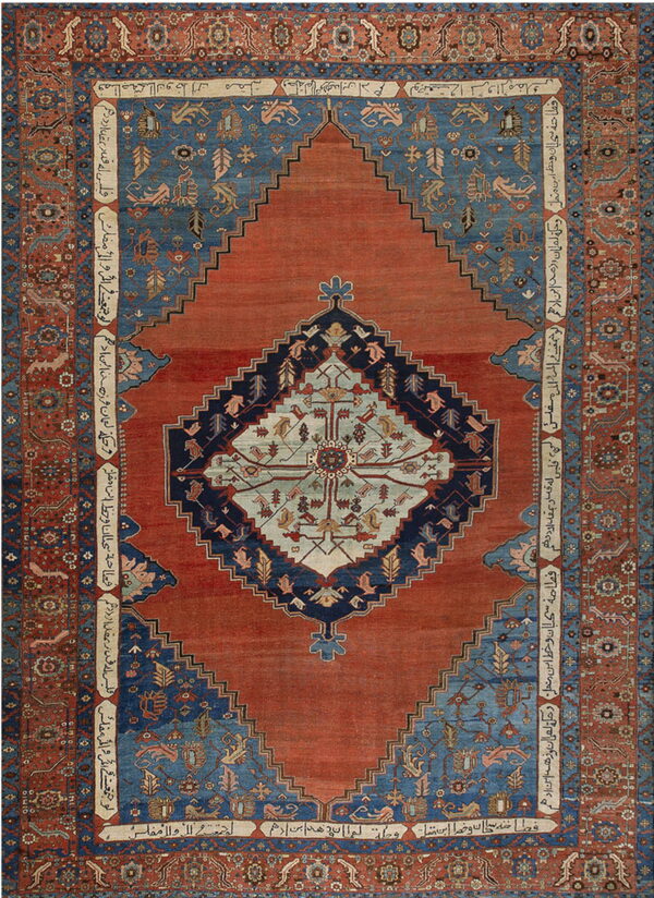 Ornate rust and blue geometric rug featuring a large stepped medallion and decorative borders with script.