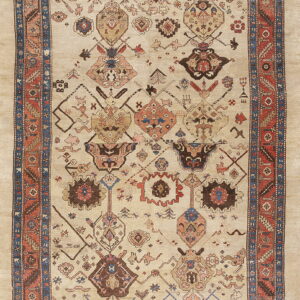 Light beige rug featuring rust and blue multi-layered borders and an overall tribal pattern field.