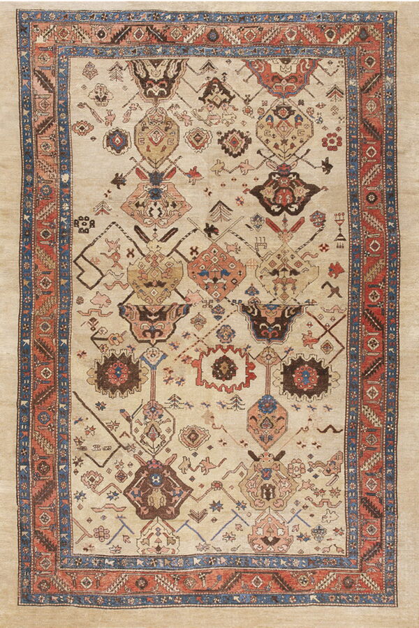 Light beige rug featuring rust and blue multi-layered borders and an overall tribal pattern field.