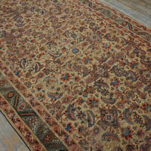 Ornate low-pile area rug in beige, red, and blue floral motifs rests on distressed gray wooden floorboards.