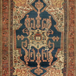 Traditional rug with a navy medallion, cream corners, and a multi-layered terracotta and blue geometric border.