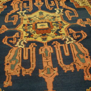 Geometric medallion rug with a navy blue field, coral accents, and detailed cream borders.