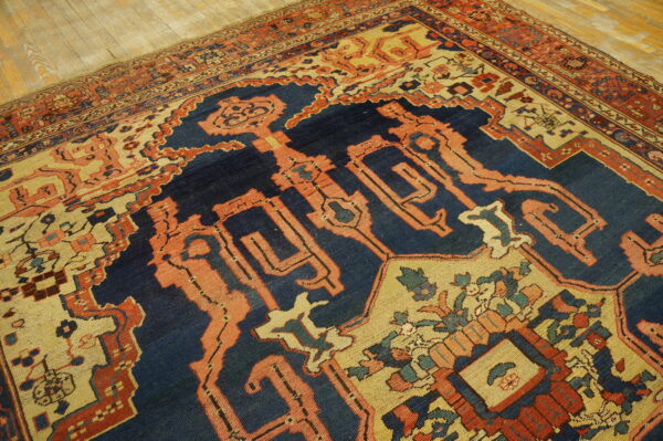 Intricate low-pile rug featuring navy, rust red, and beige geometric patterns on distressed wood flooring.