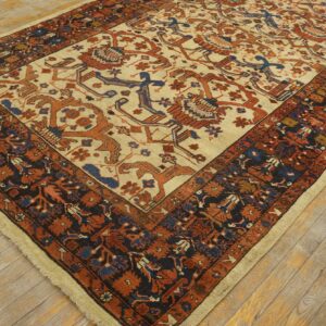 Traditional rug featuring a cream field and rust and blue patterns rests on light wood plank flooring.