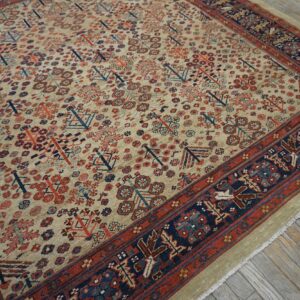 Rustic geometric rug in beige, red, and navy on distressed wood plank flooring.