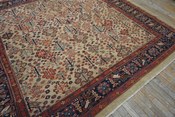 Rustic geometric rug in beige, red, and navy on distressed wood plank flooring.