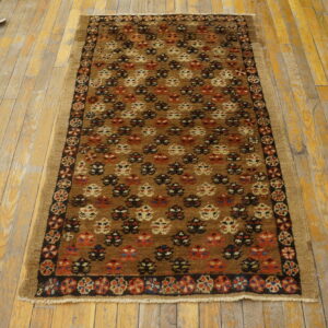Geometric brown runner rug featuring rust and cream motifs displayed on worn yellow wooden floorboards.