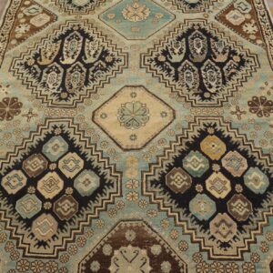Traditional rug with stepped medallions in dusty blue, black, and brown rests on distressed wood floors.