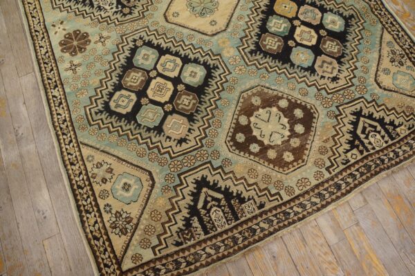 Geometric tribal rug featuring beige, aqua blue, brown, and black patterns on light wood flooring.