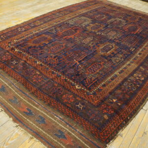 A dark blue and rust geometric rug with flatweave kilim ends lies on light yellow distressed wood floors.