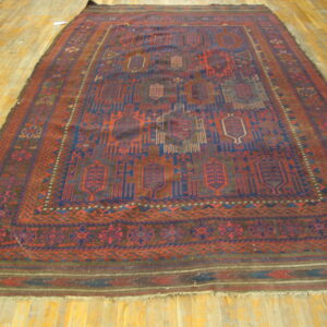 Deep red and navy geometric rug with detailed borders lies flat on polished light hardwood flooring.