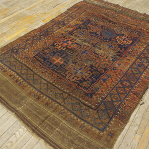Distressed geometric rug in rust, navy, and brown with flatwoven ends on light plank flooring.