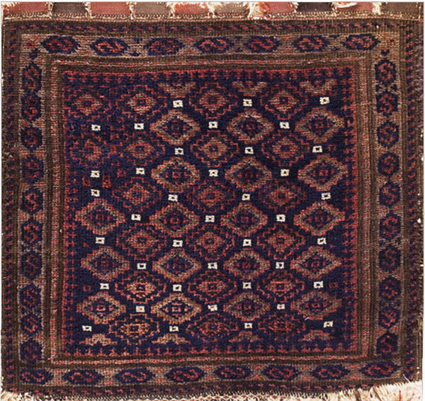 Geometric rug in navy, reddish-brown, and dark brown, featuring repeating diamond motifs and visible fringe.