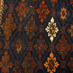 Geometric rug border and field with navy blue background and medallions in red, orange, and ivory.