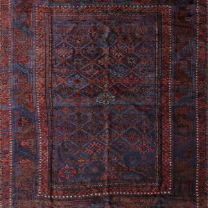 Traditional rug with a navy blue field, repeating geometric guls, and brick red and blue borders.