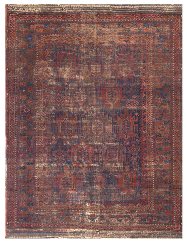Heavily distressed low-pile rug with geometric patterns in deep red, blue, and brown tones.