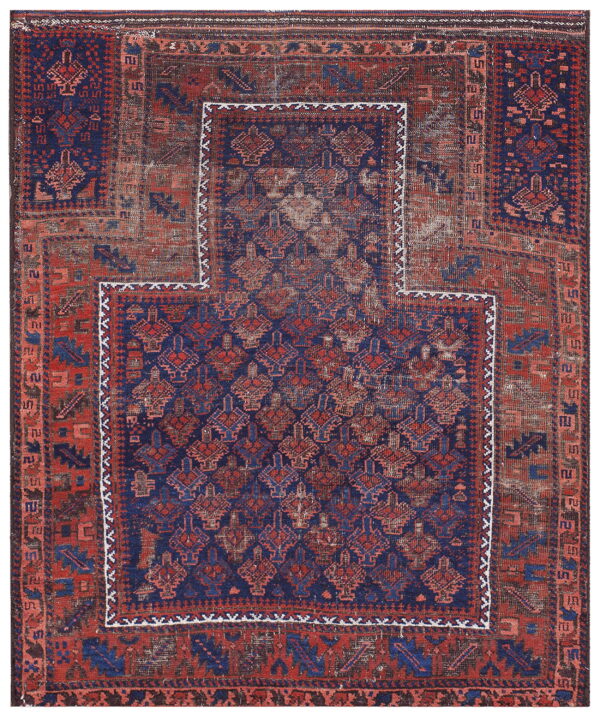 Geometric red and navy blue rug with visible wear and a large, stepped central panel outline.