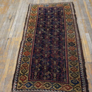 Navy and multicolor geometric runner rug displayed against distressed gray and yellow wooden planks.