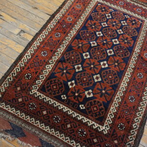 Red and navy tribal geometric rug runner with a contrasting border on light wood plank flooring.