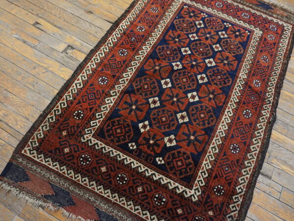 Red and navy tribal geometric rug runner with a contrasting border on light wood plank flooring.