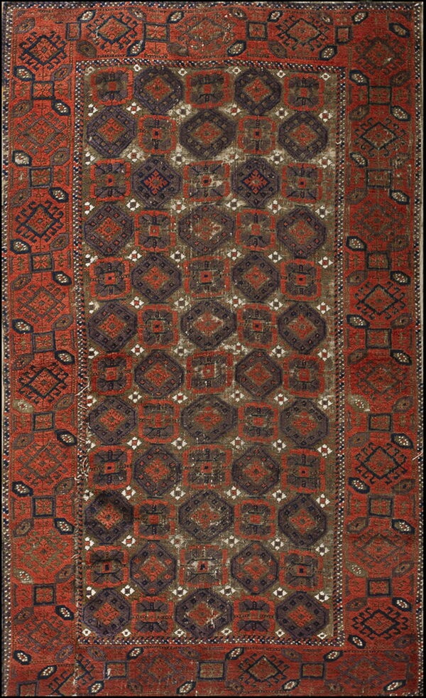 Rust-red and dark brown rug featuring repetitive geometric octagonal and square medallions in a traditional pattern.