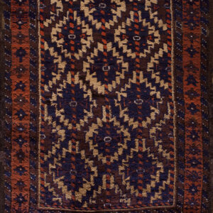 High-pile rug featuring a repeating geometric pattern in navy, tan, and dark brown with rust borders.