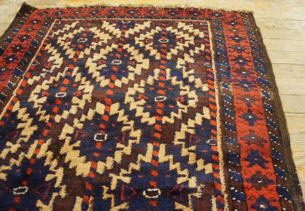 Geometric tribal rug featuring blue, red, and tan patterns on light wooden floorboards.
