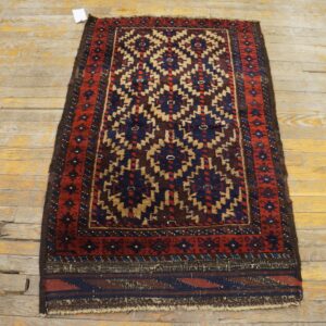 Tribal pattern rug in red, blue, and tan on heavily distressed wood floorboards.