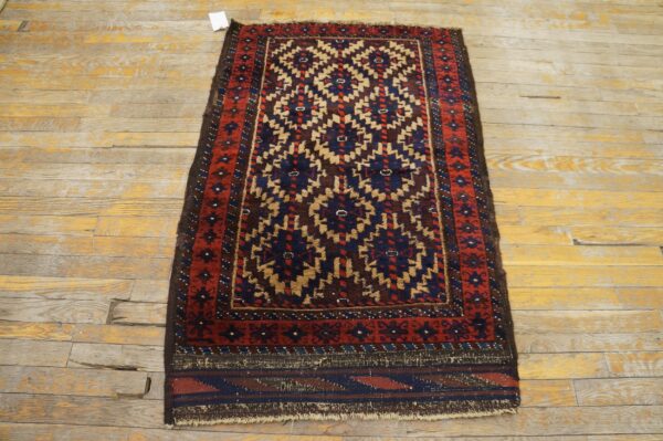 Tribal pattern rug in red, blue, and tan on heavily distressed wood floorboards.