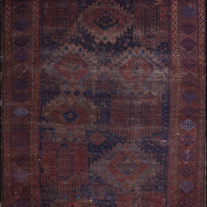 Distressed geometric rug featuring traditional patterns in deep reds, navy blue, and brownish tones.