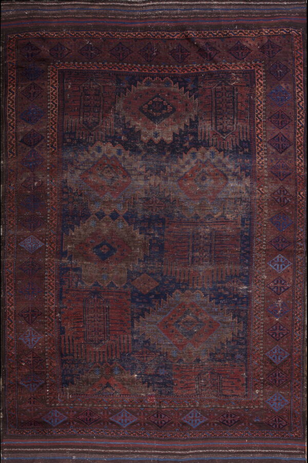 Distressed geometric rug featuring traditional patterns in deep reds, navy blue, and brownish tones.