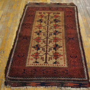 Geometric red and tan rug with a central tree motif displayed on distressed hardwood planks.