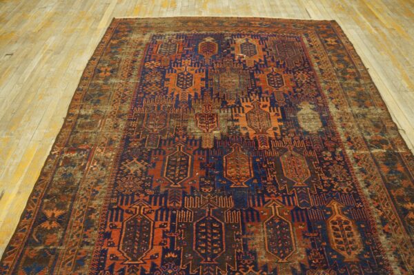 Large distressed rug featuring geometric navy and burnt orange patterns on light wood floors.