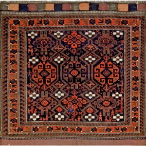 Square rug with a dark geometric pattern in rust orange, navy blue, brown, and cream accents.