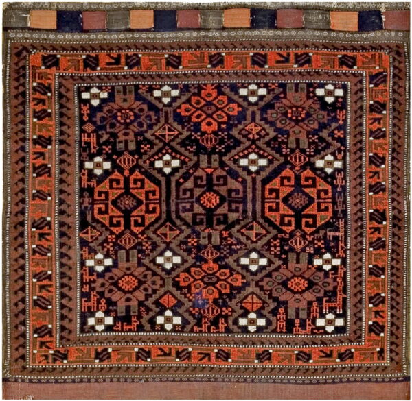 Square rug with a dark geometric pattern in rust orange, navy blue, brown, and cream accents.