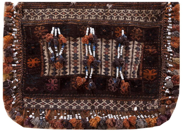 Dark brown textile featuring complex geometric patterns, contrasting textures, and ornamental tassels with white and blue beads.