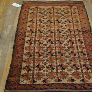Rustic geometric patterned rug in beige, rust, brown, and navy sits on weathered wood planks.