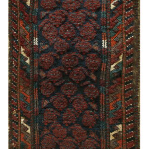 Textured runner with dark red circular motifs over an indigo field and rust, teal, and beige borders.