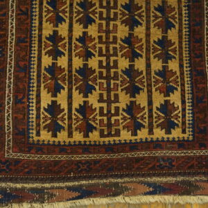 Gold field with repeating dark blue and burgundy geometric patterns on a wood plank floor.