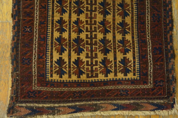 Gold field with repeating dark blue and burgundy geometric patterns on a wood plank floor.