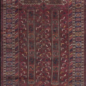 Deep burgundy rug featuring a complex geometric pattern and multiple borders with stylized octagonal medallions.