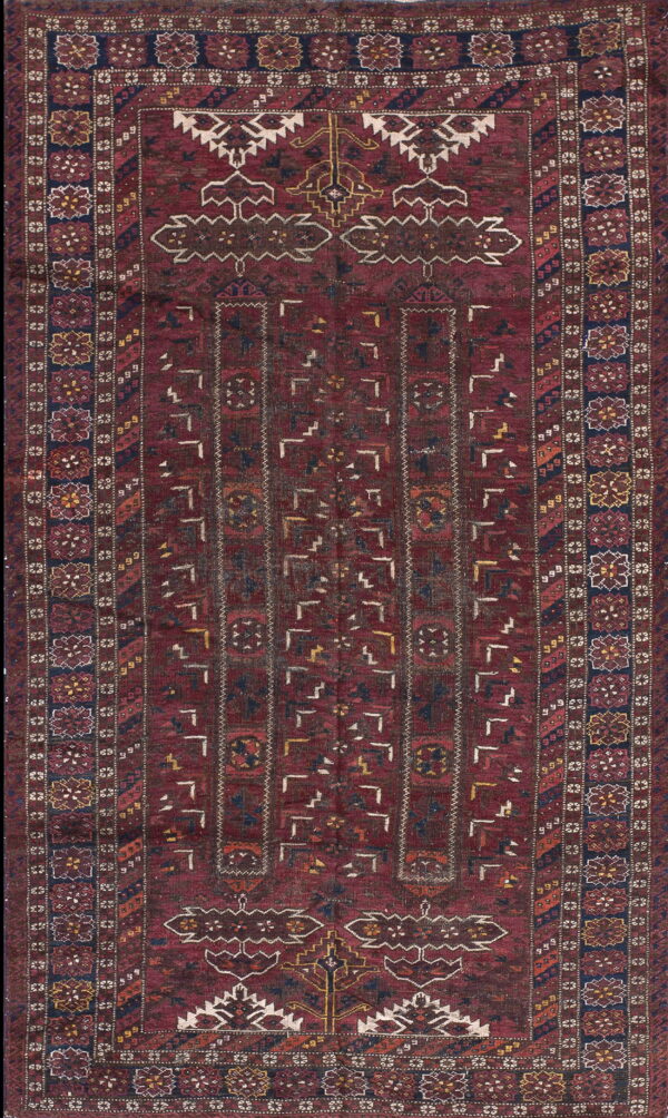 Deep burgundy rug featuring a complex geometric pattern and multiple borders with stylized octagonal medallions.