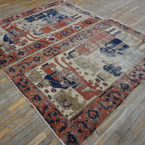 Two small, distressed rugs with beige, blue, and red figural patterns rest on gray wood planks.